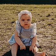 Emberlyn joined the competition — help win amazing prizes! baby, child, barefoot, headband, bow, blue_dress, striped_clothing, outdoor, grass, sunlight, shadow, sitting, ground, serious_expression, infant, nature, young_child, person, summer, casual_clothing