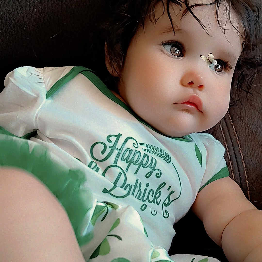 Kalani is registered to the contest to win money with this photo: baby, bodypart, clothing, couch, cushion, dress, face, finger, furniture, hand, head, homedecor, newborn, person, photography, portrait, sitting, sleeping, t_shirt, toy