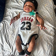 Ahmir Lamelo joined the competition — help win amazing prizes! baby, infant, child, smiling, lying_down, pacifier, headband, jordan, socks, clothing, bed, blanket, pattern, hand, footwear, person, cute, happy, indoors, portrait