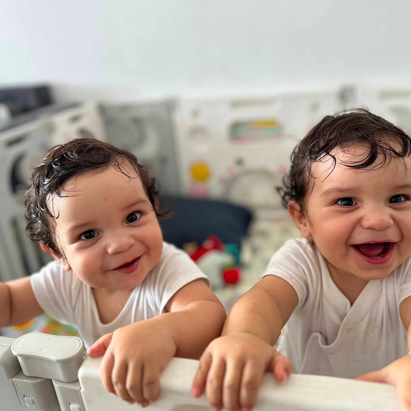 Hélio Et Ezio participe au concours pour gagner de l'argent avec cette photo : baby, child, closeup, curly_hair, cute, expression, face, hands, happy, indoor, infant, joyful, person, playful, playpen, smiling, toddler, two_children, white_clothing, young