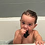 toddler, child, bath, bathtub, toy, shark, water, wet_hair, skin, face, hand, curious, indoors, bathroom, young_child, playing, cute, childhood, splash, cleaning