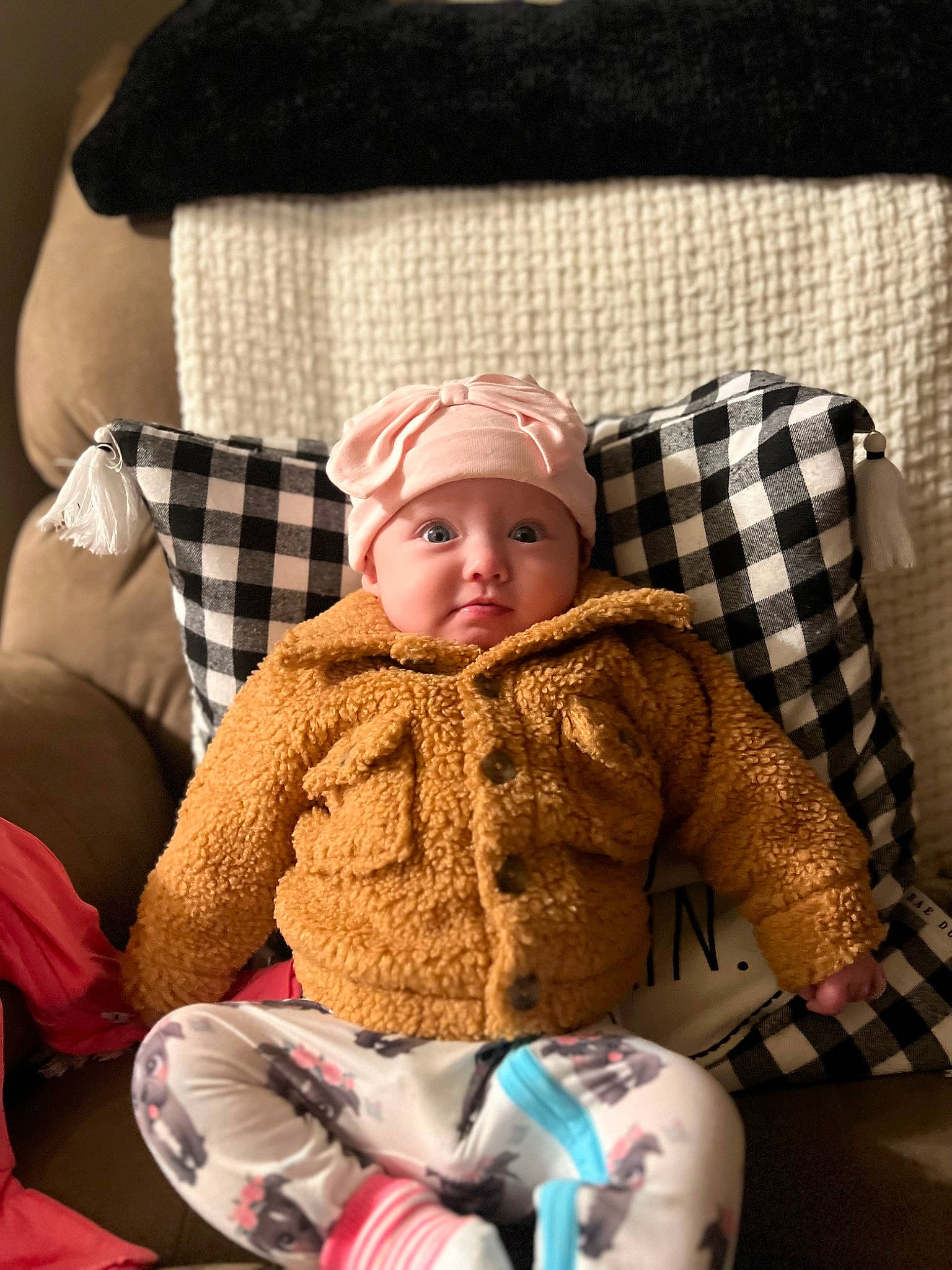Madelyn is registered to the contest to win money with this photo: baby, baby_toddler_clothing, cap, cheek, child, comfort, face, headwear, lap, linens, mammal, pattern, person, plaid, product, sitting, skin, sleeve, tartan, textile