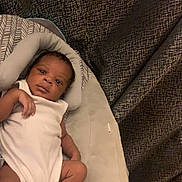 Marcus Mitchell joined the competition — help win amazing prizes! baby, infant, baby_seat, white_onesie, socks, face, eyes, hand, legs, cushion, fabric, pattern, curtains, indoors, cute, person, resting, newborn, carpet, soft