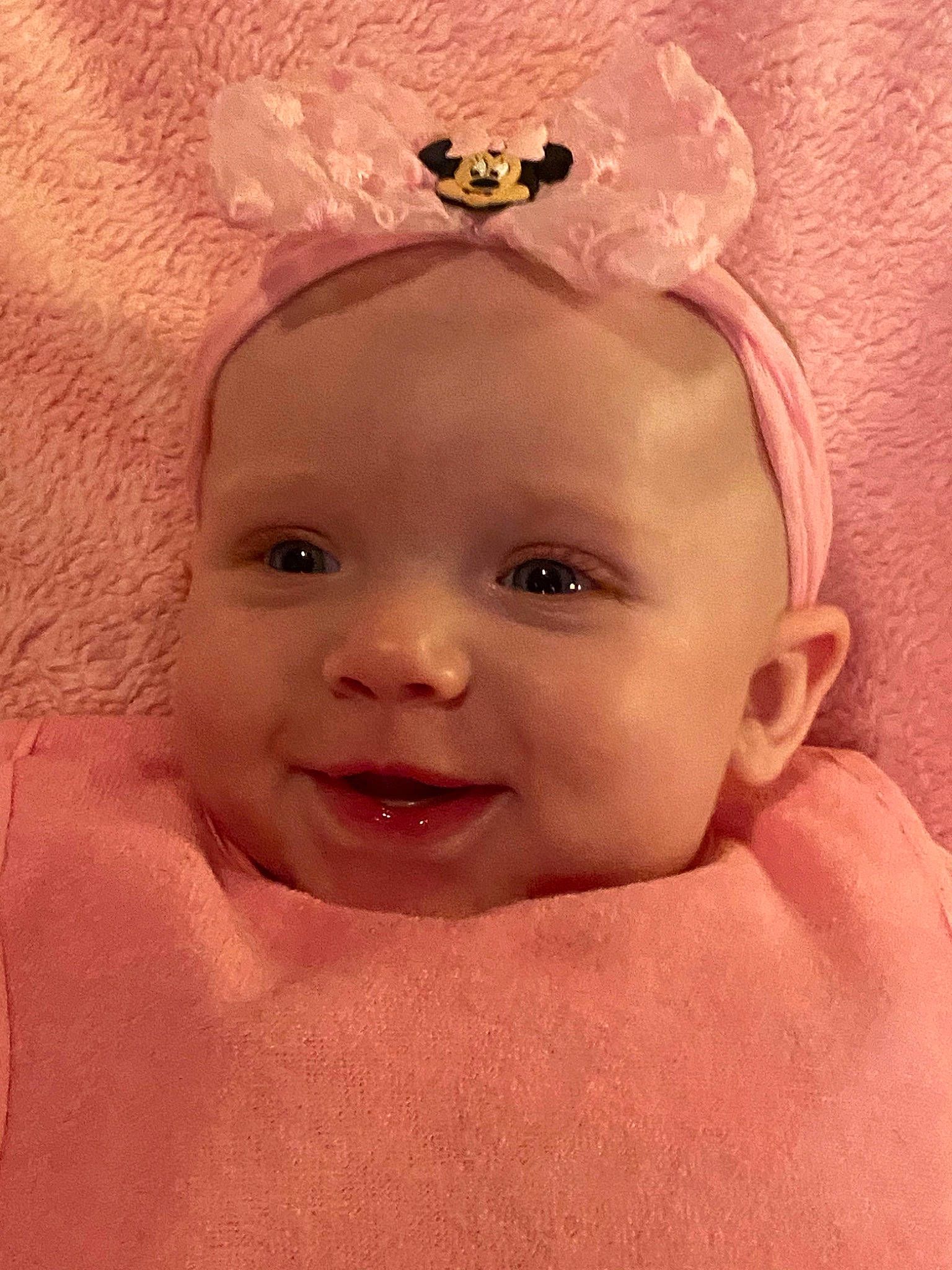 Kinsley is registered to the contest to win money with this photo: baby, cheek, child, chin, close_up, eye, eyebrow, face, forehead, hair_accessory, head, headgear, headpiece, lip, mouth, nose, person, pink, skin, smile