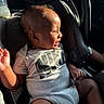 baby, child, car_seat, sunlight, smiling, nike, onesie, socks, infant, happy, seatbelt, bottle, car_interior, safety, portrait, cute, young_child, clothing, person, seat