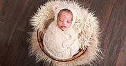 Caiden joined the competition — help win amazing prizes! newborn, baby, swaddled, sleeping, wooden_bowl, fur, fluffy, cream_color, headgear, baby_wrap, peaceful, indoors, floor, soft_texture, cute, portrait, infant, cozy, resting, child