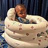 Caiden joined the competition — help win amazing prizes! baby, infant, inflatable_seat, bear_pattern, blue_curtains, blue_fabric, gold_pattern, pen, indoor, child, seated, looking_back, curious, soft_lighting, portrait, home, comfort, young_child, face, expression