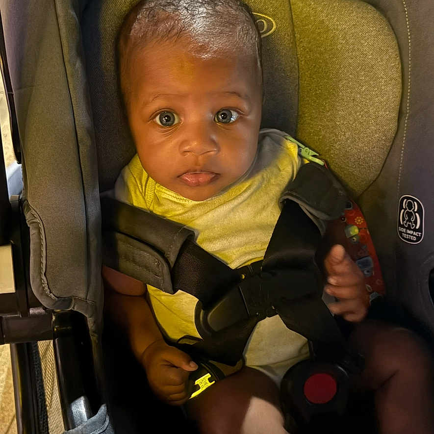 Caiden is registered to the contest to win money with this photo: baby, car_seat, child, infant, seatbelt, yellow_clothing, socks, indoors, seat, young_child, portrait, looking_at_camera, secure, cute, small_hands, bright_eyes, child_safety, infant_seat, baby_boy, young_infant