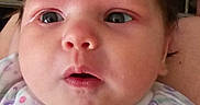 Elodie is registered to the contest to win money with this photo: baby, infant, face, portrait, clothing, onesie, expression, curious, child, person, skin, hair, head, closeup, newborn, cute, small, indoors, young, human