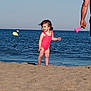 adult, beach, child, daytime, hair, happy, ocean, outdoor, person, pink, sand, sand_toy, sky, summer, sunny, swimsuit, toddler, toy, water, waves