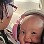 Valerian Jo joined the competition — help win amazing prizes! baby, child, headphones, airplane, window, adult, glasses, earrings, smile, travel, portrait, closeup, seatbelt, jacket, person, cute, happy, indoor, carrier, cozy