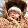 baby, sleeping, hat, hood, jacket, brown, cozy, warm, infant, cute, face, child, soft, knit, zipper, closed_eyes, fur, clothing, portrait, indoors