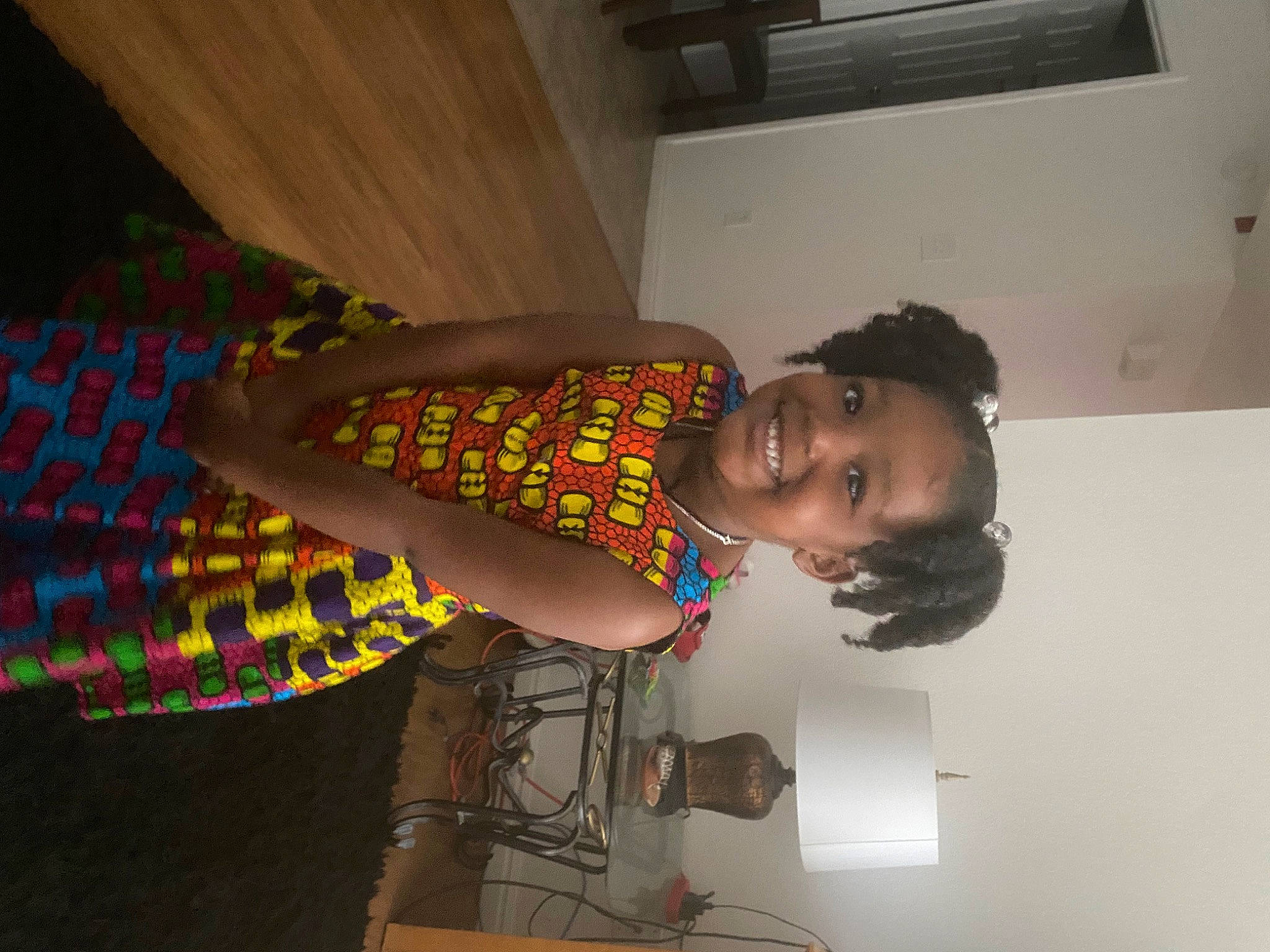 Gianna is registered to the contest to win money with this photo: abdomen, black_hair, elbow, fashion_design, fun, happy, human_leg, joint, joy, knee, pattern, person, room, shoulder, sleeve, smile, t_shirt, thigh, toddler, trunk