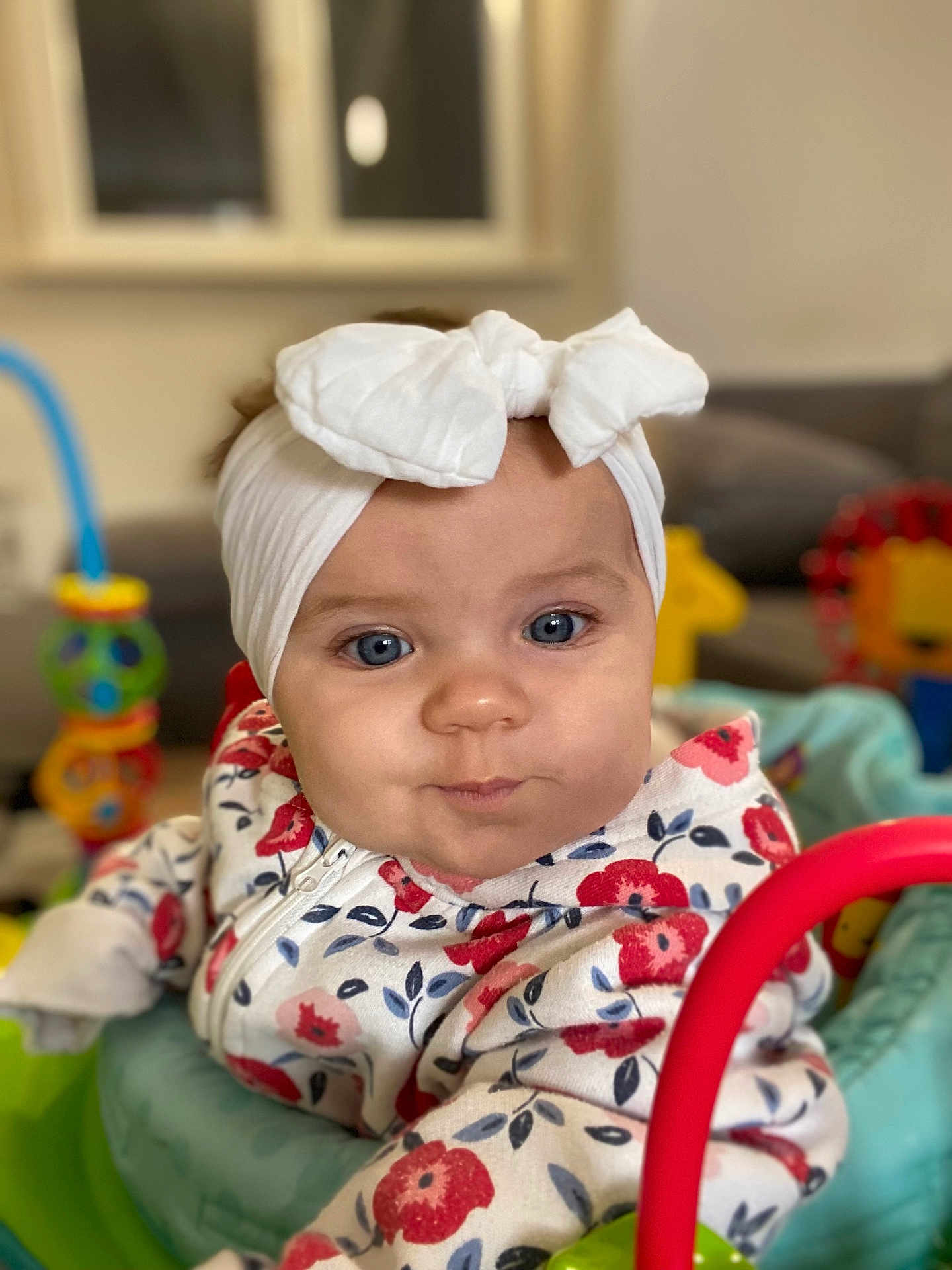 Manel a rejoint le concours — aidez-le/la à gagner de superbes lots ! baby, child, infant, headband, bow, blue_eyes, floral_clothing, toy, indoor, colorful, face, closeup, cute, seated, play_area, person, expression, soft_lighting, portrait, young_child