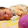 Gracie is registered to the contest to win money with this photo: baby, infant, lying_down, blanket, toy_ball, colorful, cute, child, face, skin, clothing, soft_toys, playtime, indoors, portrait, newborn, resting, small, peaceful, expression
