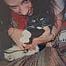Dana is registered to the contest to win money with this photo: black_and_white_cat, blanket, candid, casual, cat, close_up, cozy, face, feline, fur, hands, hugging, indoor, intimate, person, pet, pillow, resting, warm, watching