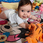 Azurhya a rejoint le concours — aidez-le/la à gagner de superbes lots ! baby, infant, smiling, lying_down, white_clothing, toy, plush_toy, teething_ring, cartoon_bedspread, colorful, indoor, child, cute, happy, face, person, playful, soft_toys, bedroom, young_child