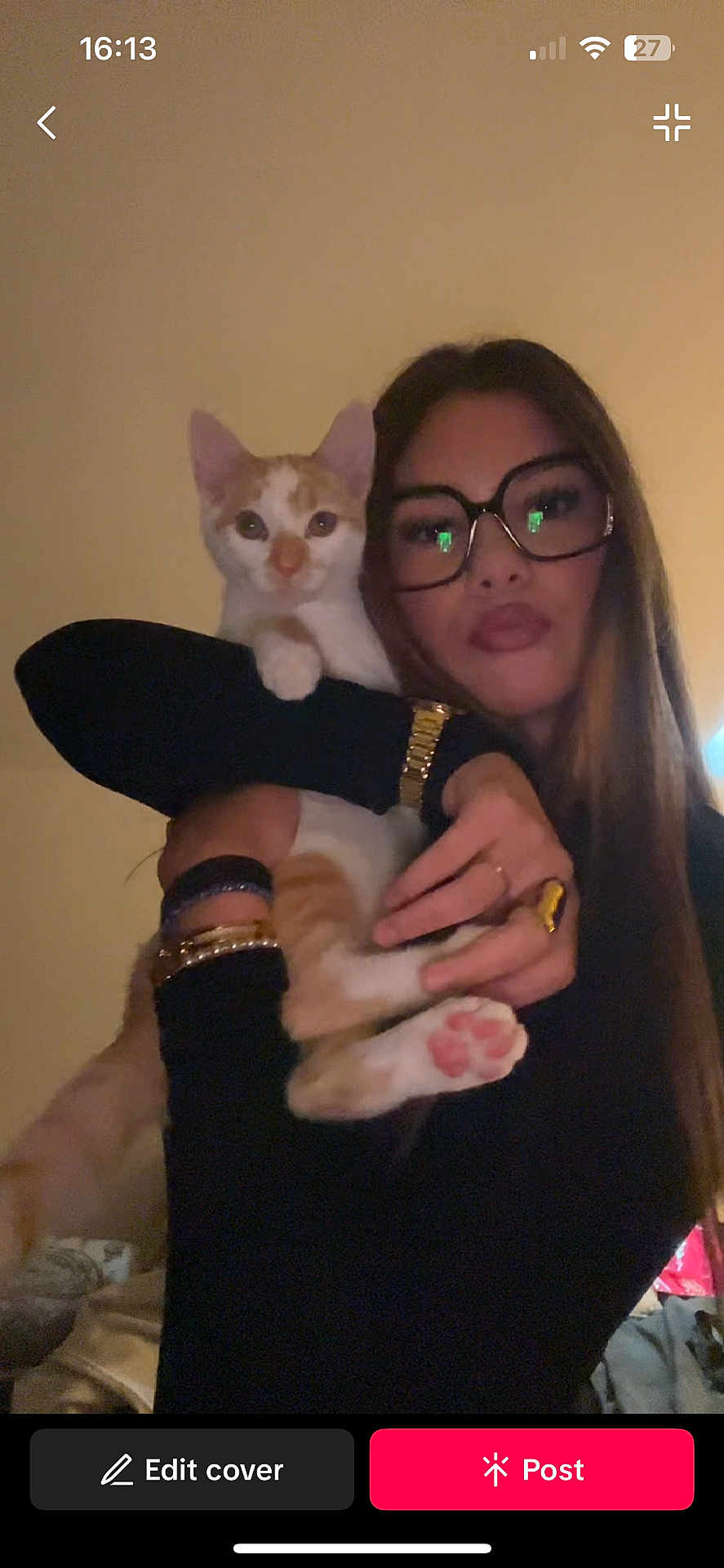 Appo a rejoint le concours — aidez-le/la à gagner de superbes lots ! woman, cat, glasses, indoor, pet, orange_cat, white_cat, holding, face, paw, long_hair, watch, ring, black_clothing, portrait, looking_at_camera, warm_lighting, cozy, cute, closeup
