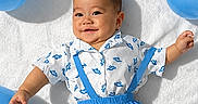Chadric Ashton joined the competition — help win amazing prizes! baby, child, smiling, portrait, lying_down, blue_balloons, white_blanket, suspenders, blue_clothing, outdoor, sunlight, happy, infant, face, arms, hands, baby_fashion, celebration, playful, photography