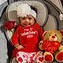 Reina is registered to the contest to win money with this photo: baby, infant, smiling, headband, flower, onesie, valentines_day, teddy_bear, rose, baby_seat, portrait, cute, pink_socks, heart_pattern, red_clothing, toy, indoor, holiday, happy, fabric
