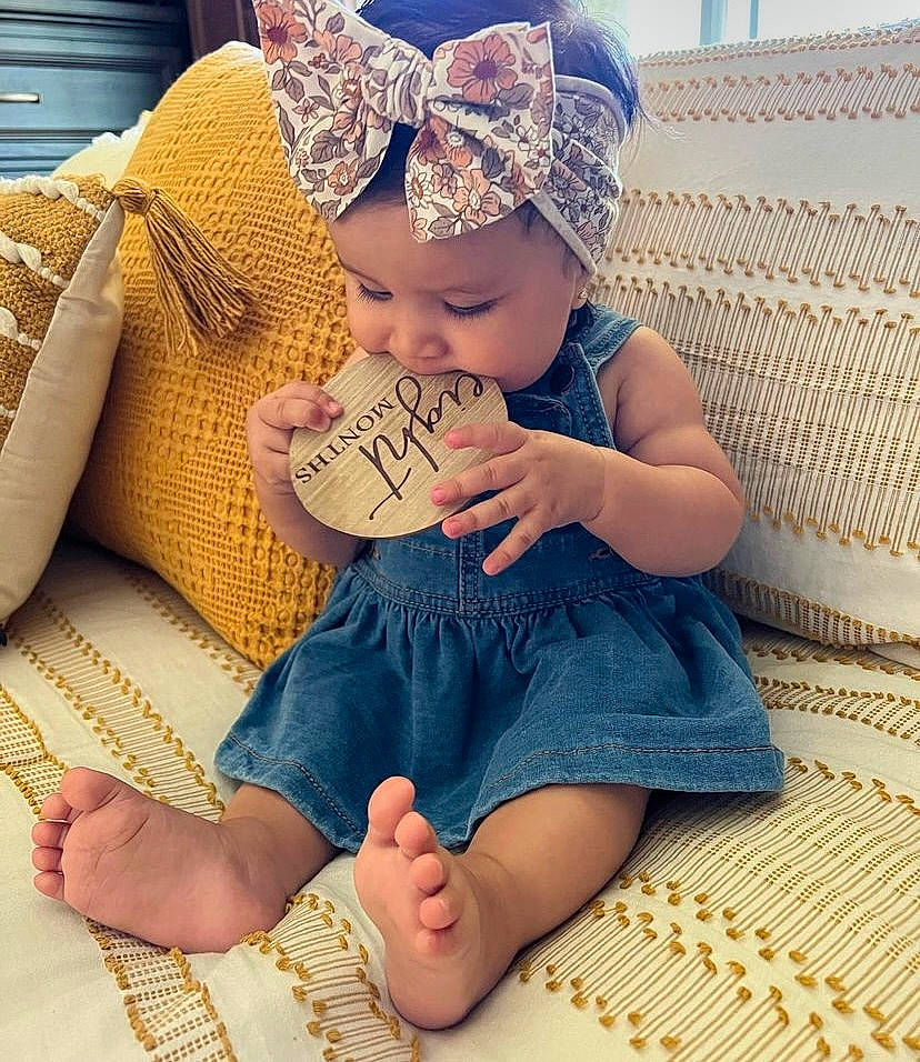 Maggie joined the competition — help win amazing prizes! baby, baby_toddler_clothing, blue, cap, child, comfort, facial_expression, finger, foot, hand, happy, hat, headwear, human_leg, lap, leg, pattern, person, skin, textile