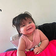 Sol Rachelle is registered to the contest to win money with this photo: baby, child, smiling, portrait, indoor, couch, blanket, pink_blanket, toy, sitting, face, head, hair, eyes, mouth, clothing, sleeveless_top, happy, home, photography