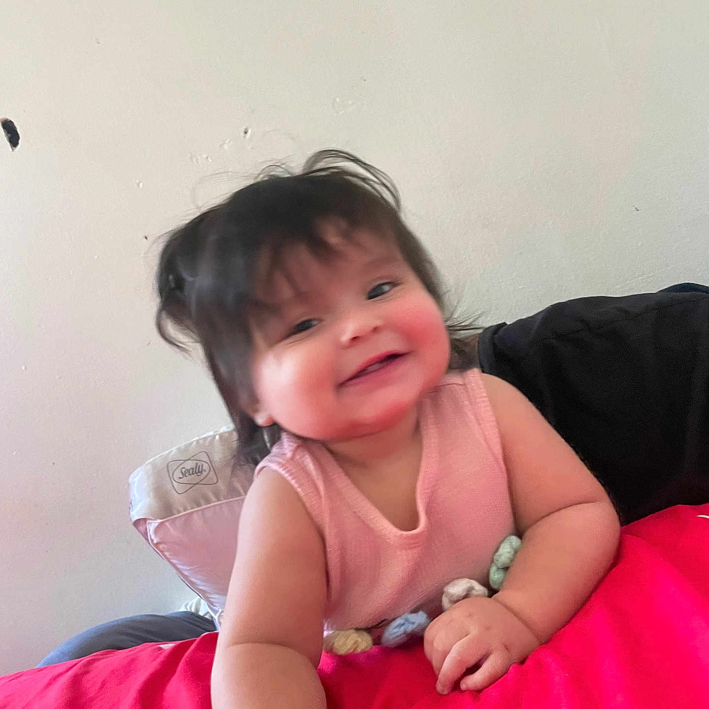 Sol Rachelle is registered to the contest to win money with this photo: baby, child, smiling, portrait, indoor, couch, blanket, pink_blanket, toy, sitting, face, head, hair, eyes, mouth, clothing, sleeveless_top, happy, home, photography