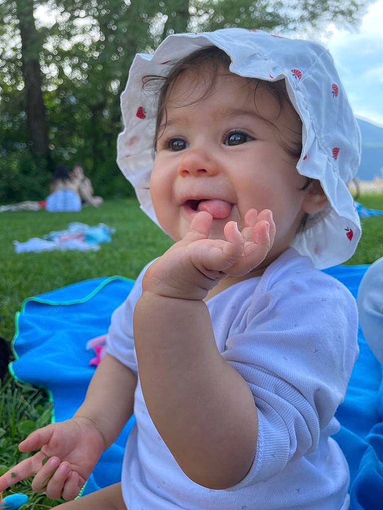 Ambre participe au concours pour gagner de l'argent avec cette photo : azure, baby, baby_toddler_clothing, blue, cap, chin, grass, happy, hat, headwear, leaf, leisure, lip, people_in_nature, person, pink, plant, public_space, skin, smile