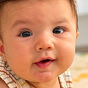Dylan is registered to the contest to win money with this photo: baby, child, infant, portrait, face, eyes, smiling, curious, indoor, close_up, photography, head, hair, skin, striped_outfit, sleeveless, sitting, warm_lighting, cozy, person