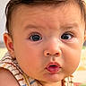 baby, child, infant, portrait, close_up, face, eyes, wide_eyed, surprised, puckered_lips, short_hair, brown_hair, striped_outfit, sleeveless, sitting, indoor, warm_lighting, photography, adorable, person