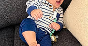 Dylan joined the competition — help win amazing prizes! baby, child, infant, smiling, sunglasses, sofa, couch, indoor, portrait, seated, striped_clothing, blue_clothing, pacifier, pacifier_clip, barefoot, happy, relaxed, home, furniture, photography