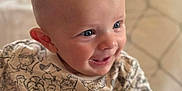 Oakley joined the competition — help win amazing prizes! baby, smiling, blue_eyes, cute, shirt, cartoon_print, child, sitting, indoor, cushion, soft_lighting, happy, portrait, close_up, infant, face, skin, cute_expression, young_child, cheerful