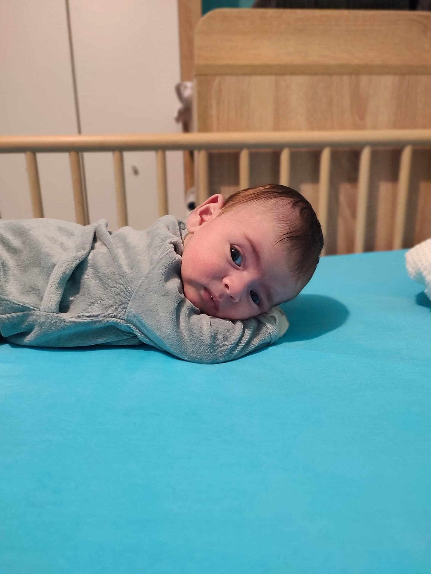 Rachid a rejoint le concours — aidez-le/la à gagner de superbes lots ! baby, infant, lying_down, blue_bed, crib, wooden_crib, curious, face, head, clothing, indoor, resting, young_child, portrait, skin, sleepwear, baby_bed, baby_gaze, child, calm