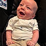 baby, smiling, infant, car_seat, clothing, white_shirt, sailboat_pattern, beige_pants, happy, cute, child, portrait, blue_eyes, skin, person, sitting, closeup, young_child, casual_wear, infancy