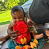 baby, child, watermelon, fruit, outdoor, picnic, plate, table, greenery, person, adult, eating, summer, happy, smile, hand, foot, nature, food, family