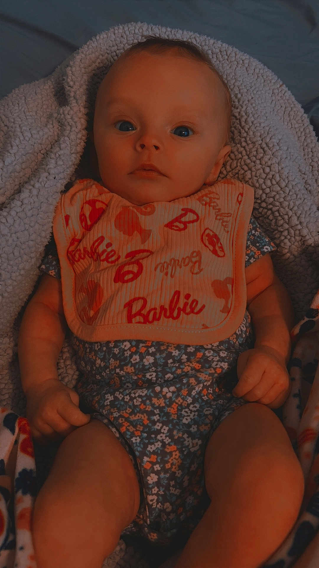 Brinley Rose joined the competition — help win amazing prizes! baby, infant, bib, blanket, clothing, patterned_clothing, face, hands, legs, blue_eyes, expression, portrait, indoor, cute, child, newborn, soft_texture, comfort, lying_down, casual