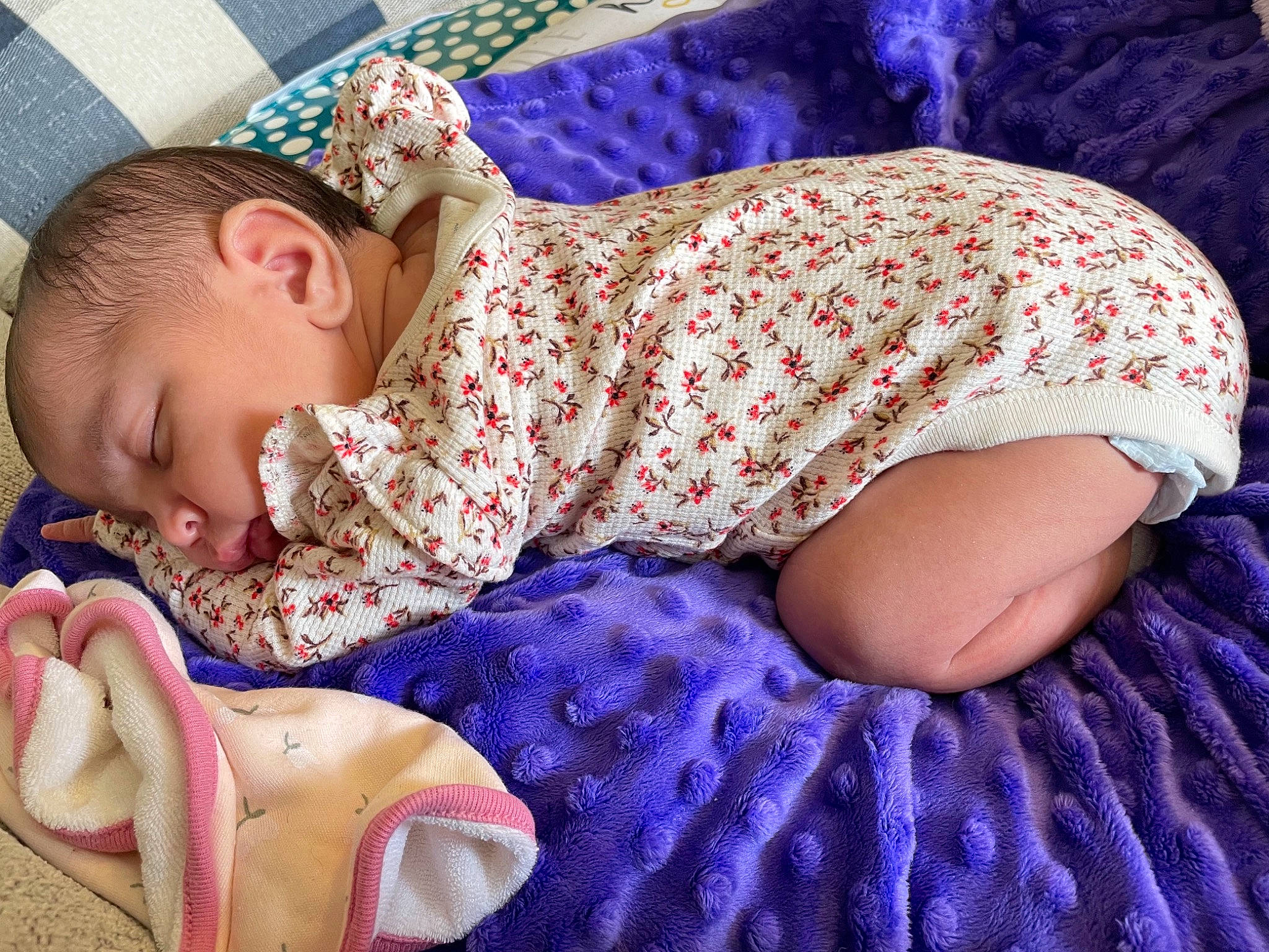 Kamilla is registered to the contest to win money with this photo: arm, baby, baby_products, baby_sleeping, baby_toddler_clothing, bedding, blue, child, comfort, finger, human_leg, linens, magenta, pattern, person, pink, purple, skin, sleeve, textile