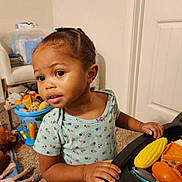 Halo joined the competition — help win amazing prizes! toddler, child, toy_food, play_table, braided_hair, curious_expression, floral_shirt, indoor, carpet, chair, bucket, stuffed_animals, doll, door, hand, face, person, playing, room, home