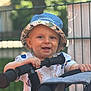 Thiago a rejoint le concours — aidez-le/la à gagner de superbes lots ! baby, blurred_background, bucket_hat, child, clothing, cute, daylight, handlebar, hands, happy, hat, nature, outdoor, person, playful, portrait, smiling, stroller, toddler, young_child