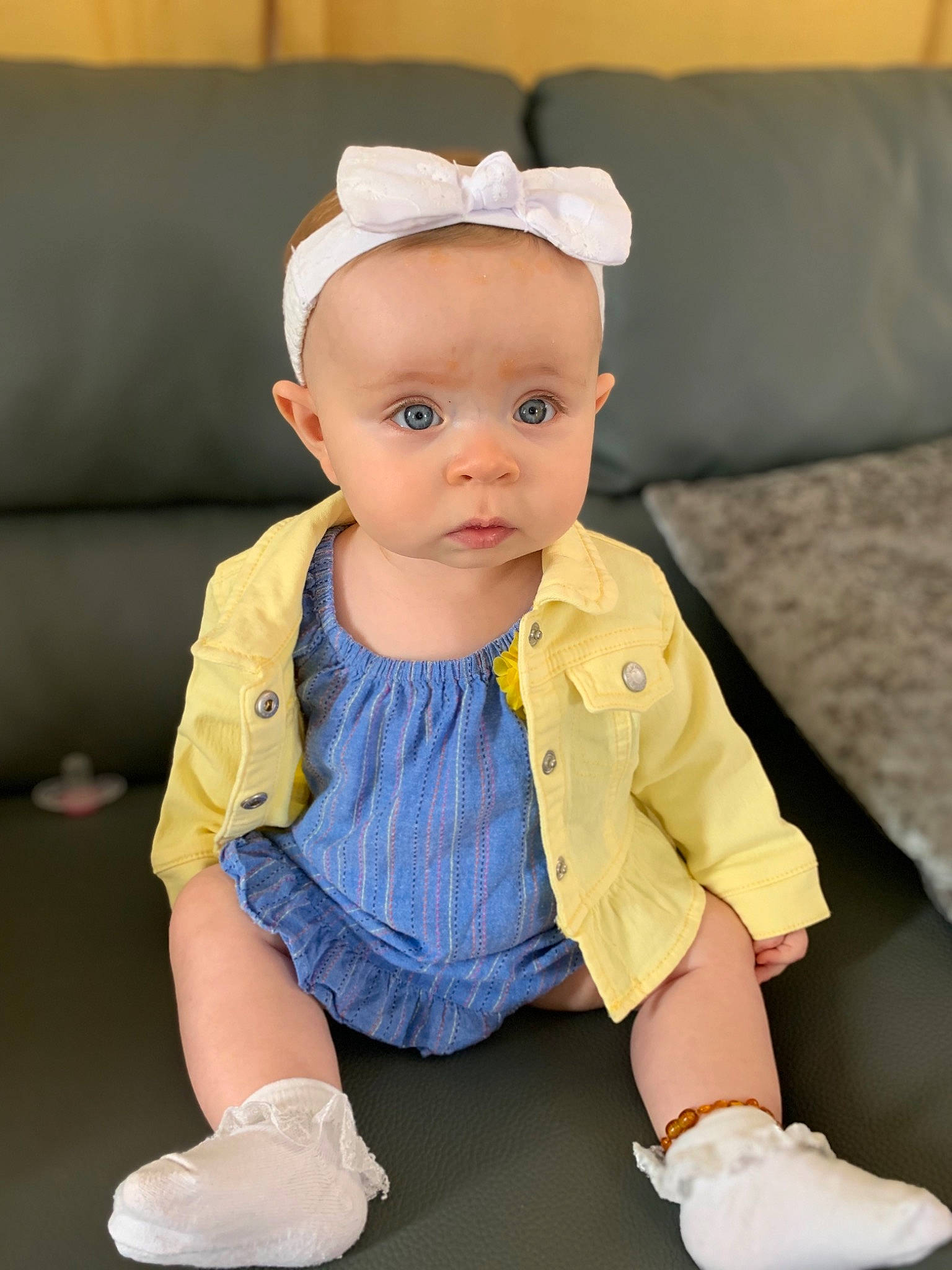 Ayda is registered to the contest to win money with this photo: baby, baby_toddler_clothing, child, child_model, ear, footwear, hair_accessory, headgear, person, product, shoe, sitting, skin, sleeve, toddler, yellow