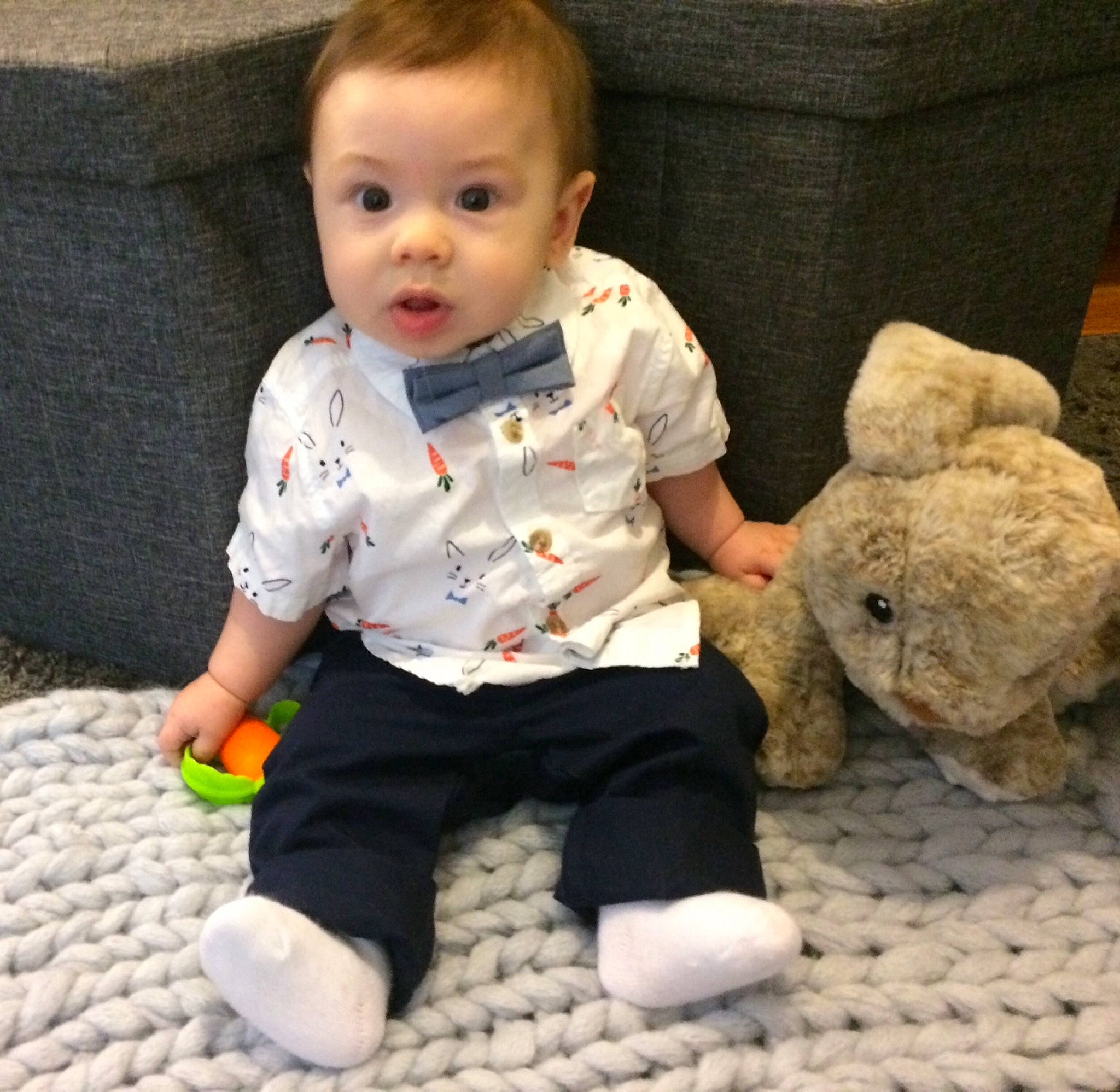 Lucius is registered to the contest to win money with this photo: baby, baby_toddler_clothing, cheek, child, ear, eye, head, person, play, plush, room, sitting, skin, sleeve, smile, stuffed_toy, surprise, t_shirt, teddy_bear, toddler
