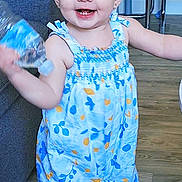 énaya participe au concours pour gagner de l'argent avec cette photo : barefoot, blue_eyes, chair, child, cute, dress, flooring, furniture, happy, home, indoor, person, pigtails, playful, smiling, sofa, toddler, walking, water_bottle, young
