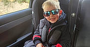 Cruze joined the competition — help win amazing prizes! blond_hair, car, car_seat, casual_clothing, child, daylight, dog, happy, jacket, pants, pet, road_trip, seatbelt, smile, spiderman, sunglasses, travel, vehicle_interior, window, young_child