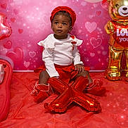 Raelynn is registered to the contest to win money with this photo: toddler, child, red, white, balloon, heart, decoration, cute, sitting, portrait, indoors, celebration, festive, smiling, hat, toy, gold, floor, clothing, background