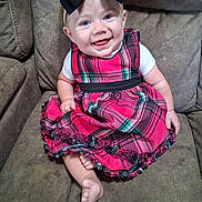Charlee joined the competition — help win amazing prizes! baby, child, smiling, dress, plaid, headband, bow, couch, seated, indoors, foot, white_shirt, happy, person, portrait, cute, infant, furniture, skin, blue_eyes