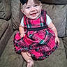 baby, child, smiling, dress, plaid, headband, bow, couch, seated, indoors, foot, white_shirt, happy, person, portrait, cute, infant, furniture, skin, blue_eyes