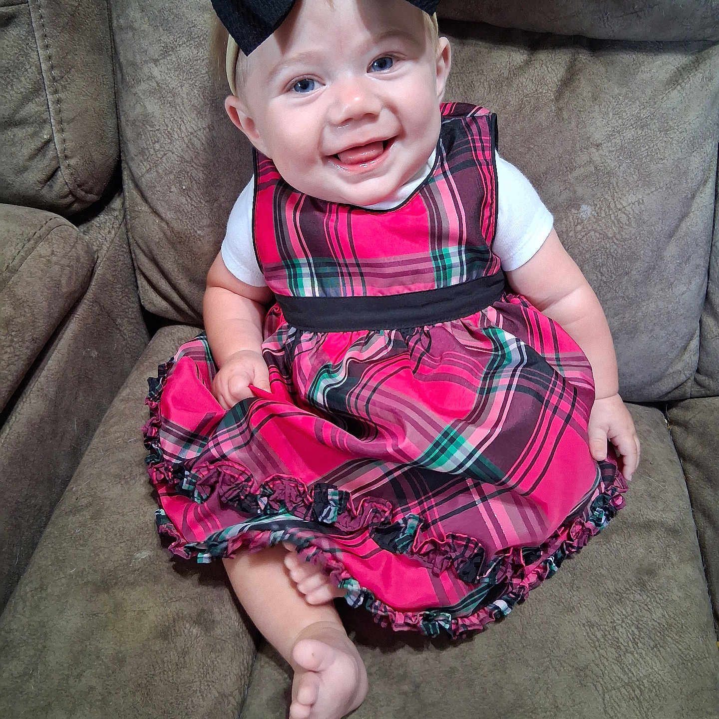 Charlee joined the competition — help win amazing prizes! baby, child, smiling, dress, plaid, headband, bow, couch, seated, indoors, foot, white_shirt, happy, person, portrait, cute, infant, furniture, skin, blue_eyes