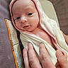 Scarlett is registered to the contest to win money with this photo: baby, infant, towel, hooded_towel, hand, skin, face, eyes, smile, person, newborn, cozy, soft, indoor, closeup, portrait, cute, warm, comfort, care