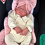 newborn, baby, sleeping, pink_bow, white_outfit, car_seat, cushion, infant, closed_eyes, headband, child, soft_texture, cozy, resting, pink, black_background, no_smoking_sign, small_hands, cute, portrait