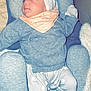 baby, child, infant, gray_sweater, turban, bib, sheep_pattern, pants, cushioned_seat, blanket, cozy, indoor, soft_fabric, cute, comfort, relaxed, person, clothing, headwear, portrait